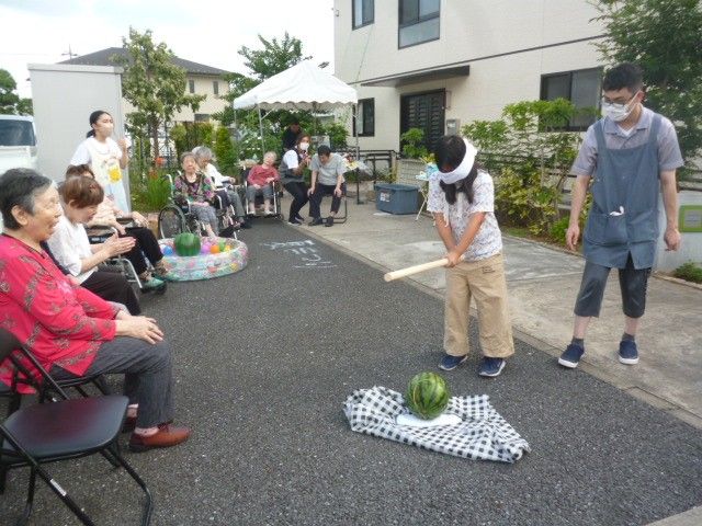 笑顔で介助するスタッフ 中庭 温かな雰囲気の中庭で利用者と一緒に活動。共に楽しむスタッフの姿が印象的です。
