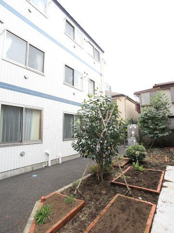 白壁の建物と植栽エリア 植え込み 緑に囲まれた清潔な外観は、心安らぐ環境を提供しています。ご自身の働く場として、ぜひ一度足を運んでみてください。