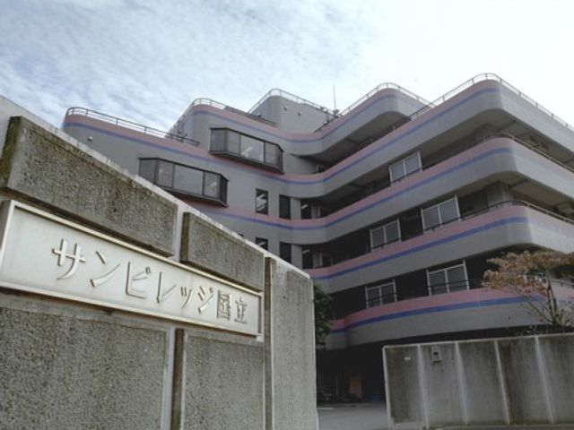 サービス付き高齢者住宅 外観 上層階に穏やかな曲線を描く建物の前景には、しっかりとした造りのサインモニュメントが映えています。