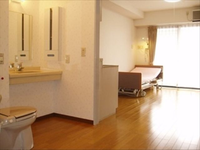 明るい居室 居室 ゆとりある居室は清潔感があり、広々とした洗面台とベッドが配置されています。日々の生活に必要な設備が揃っており、安心してご利用いただける環境です。