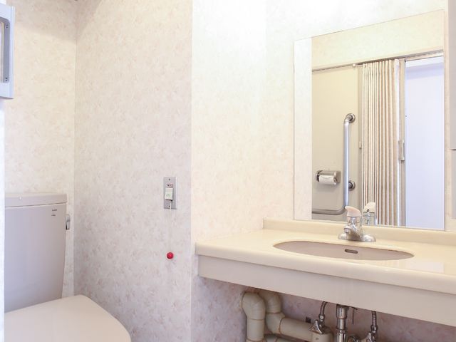 清潔なトイレ洗面所 トイレ 機能的なデザインの洗面スペースで、日々の清掃がしやすい構造になっております。手すりも設置されていて、安全面にも配慮されています。