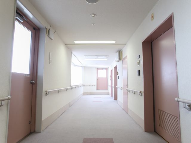 明るい廊下の風景 廊下 手すりが整備された清潔感のある廊下です。安全に配慮されたデザインで、ゆったりと歩ける設計になっています。