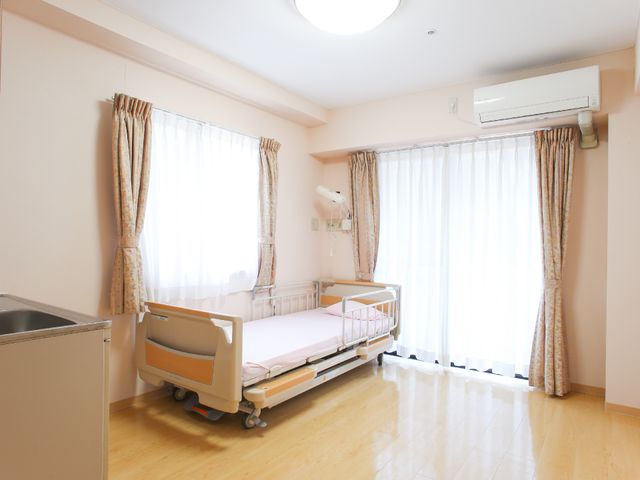 明るい居室の窓辺 居室 この居室は日差しがたっぷりと入る明るい作りです。ゆったりとした時間をお過ごしいただける環境が整っています。