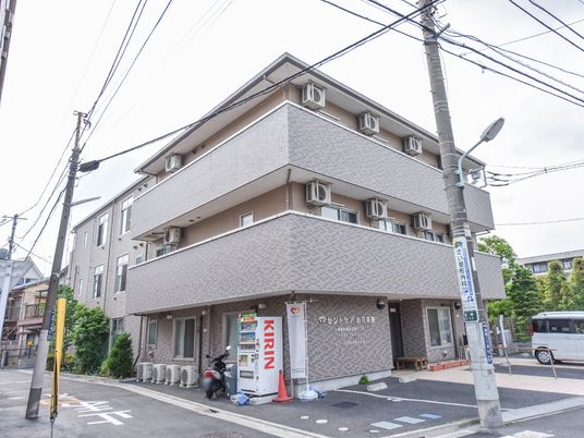 都会の角地建物エントランス