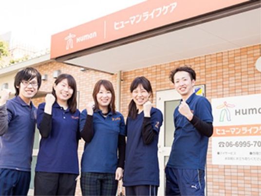 笑顔のスタッフと施設外観
