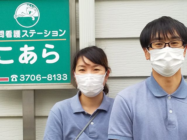 訪問看護の看板前 看板 スタッフは訪問看護の案内をしています。看板が設置された場所で情報を確認できます。