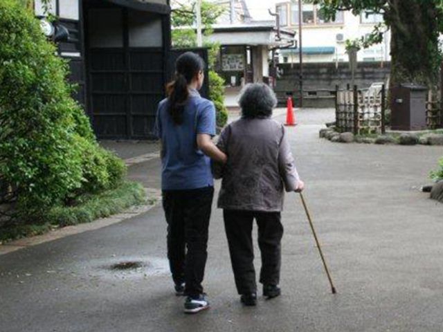 散策する人々の様子 外観 緑豊かな場所で、利用者とスタッフが一緒に散策を楽しんでいます。和やかな雰囲気が漂います。