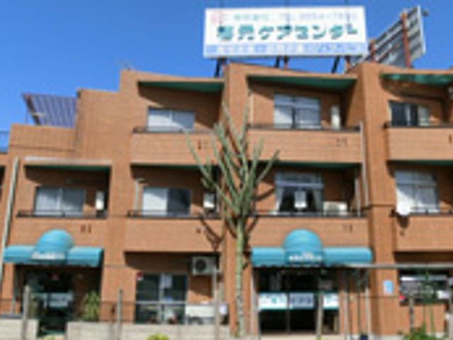 茶色い建物の外観 外観 落ち着いた雰囲気の茶色い建物で、訪れる人々を温かく迎えます。豊かな緑も魅力となっています。