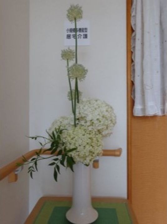 白い花瓶の生花と手すり
