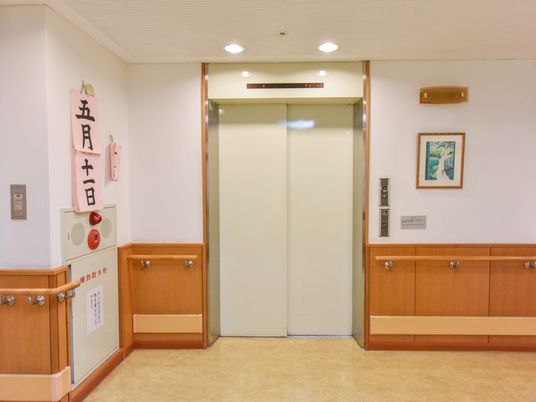 館内には、白い扉のエレベーターが完備されている。周囲の壁には手すりが設置され、防火設備も整えられている。