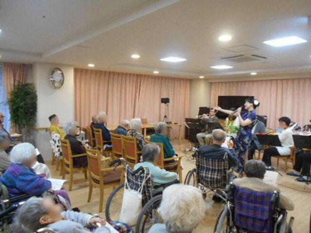 音楽会のあるラウンジ イベント 椅子に座る方々が集い、生演奏を聴きながら穏やかな時を過ごしています。音楽を通じて心地よいコミュニケーションが生まれる空間です。