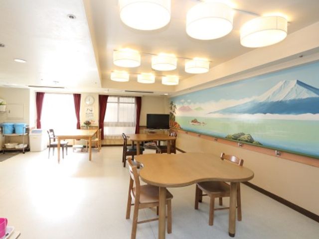 共有スペースの居心地良さ ダイニング ゆったりとした食堂で、大きな窓から自然光が差し込み、壁には富士山の絵が飾られ、落ち着いた空間を演出しています。テーブル周りには椅子が配置され、交流の場としても最適です。