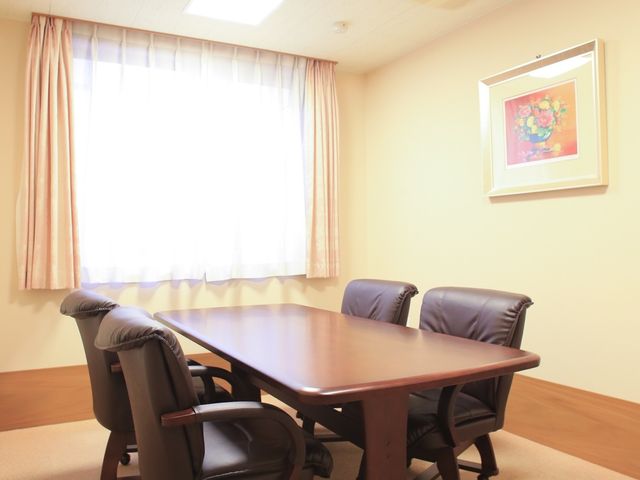 温かみのある会議室 談話スペース ゆったりとした会議用テーブルと椅子が配置された明るい部屋で、スタッフ間のコミュニケーションや研修にも最適な空間です。