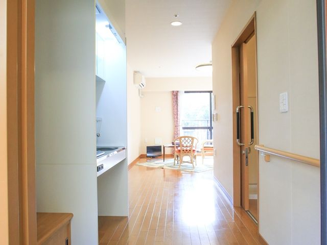 居室の入口とリビング 居室 床が木目調で明るい空間の居室です。キッチンスペースとの距離も近く、日々の生活が快適に感じられそうです。