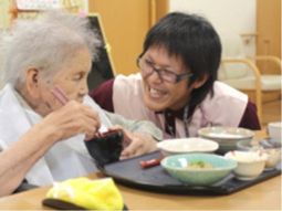 食事サポートするスタッフと利用者