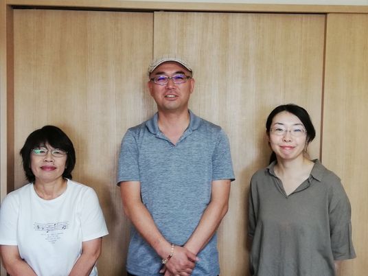 スタッフ3人が並ぶ室内  