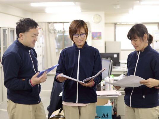 スタッフが書類確認する事務室  