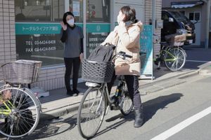 施設前で利用者とスタッフが対話