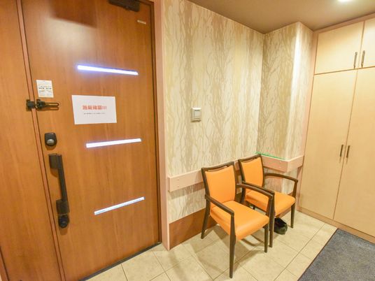 木目調の扉と椅子の廊下
