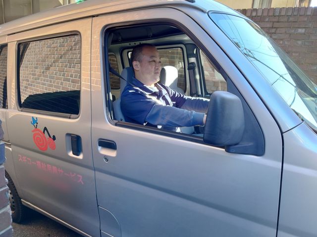 車の運転をする人 スタッフイメージ 安全運転で入居者の皆様の送迎をするスタッフの様子です。リラックスした雰囲気が伝わります。