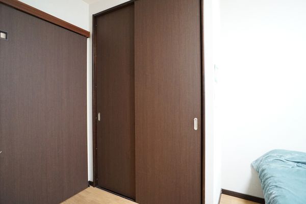 茶色い扉とベッドの一部
