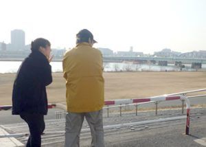 川沿いで話す人々