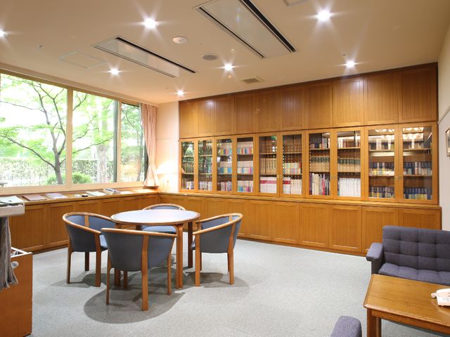 読書スペースの静かな風景 待合室 広々としたラウンジは、落ち着いた色合いで、読書や静かなお話にぴったりの空間です。窓からは自然光が差し込み、外の緑も楽しめます。
