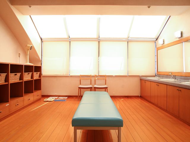 機能訓練室の明るい空間 脱衣所 天井に近い窓から優しい光が差し込む訓練スペースです。皆様の生活をサポートするためのさまざまな設備が整っています。