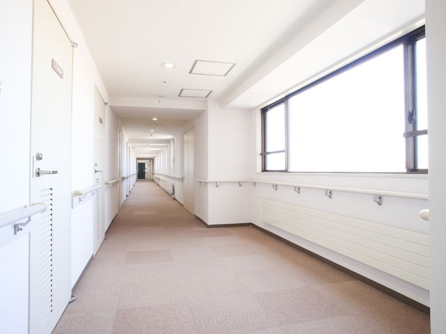 明るい廊下の風景 廊下 ゆとりある廊下は清潔感があり、天井の高い明るい造りです。手すりが設置されており、安全に配慮された環境です。