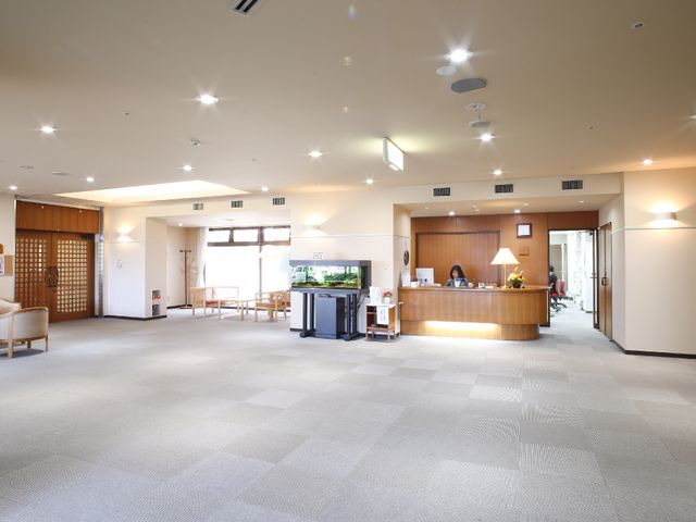 明るいエントランスホール ロビー 受付を配した開放感あるエントランスは、訪れる方々を温かく迎えます。職員の笑顔が印象的で、明るい雰囲気を感じさせる空間です。