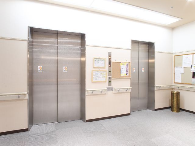清潔感のあるエレベーターホール エレベーター前ホール 手すりが付いた壁と広々としたスペースが特長のエレベーターホールです。移動の利便性を考えたアクセスが可能です。