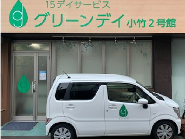車と施設の看板 看板 明るく清潔感のある施設の正面は、安心して訪れることができます。ベージュの外壁が特徴です。