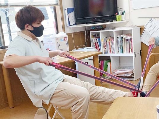 脚の運動を指導するスタッフ  