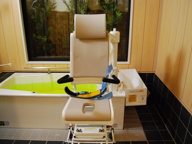 入浴用リフト付き浴室 浴室 介護用リフトが設置された浴室で、安全に配慮された入浴環境が整っています。自然光が差し込み、明るく清潔な空間が広がっています。