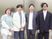 笑顔の4人が並ぶ外観前  
