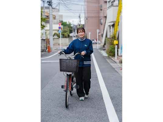 自転車を押すスタッフ