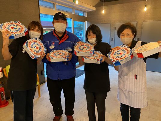 スタッフとピザのボックス