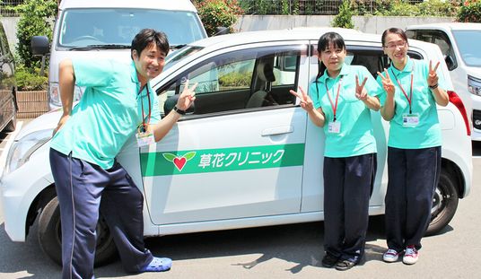 スタッフが前で笑う車