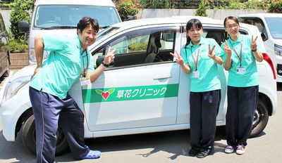 スタッフが前で笑う車