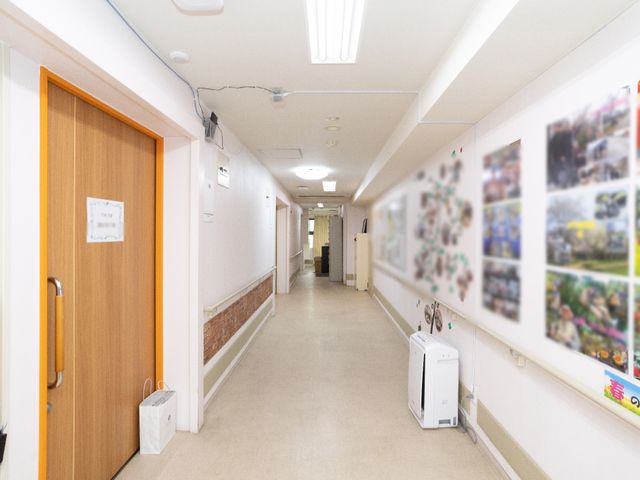 明るい廊下 廊下 広々として明るい通路は、様々な活動写真が掲示されており、温かみのある雰囲気を醸し出しています。
