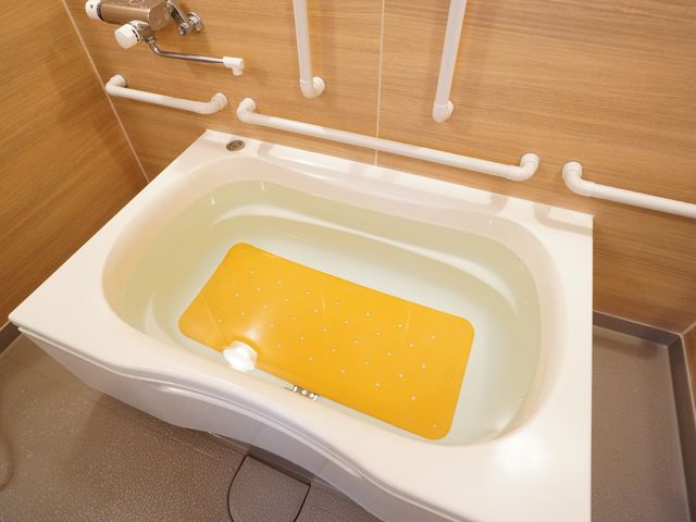 浴槽と手すり設置 浴室 安全に配慮された設計の入浴設備が整っており、安心してご利用いただけます。手すりや滑り止めがあり、快適な入浴環境を提供しています。
