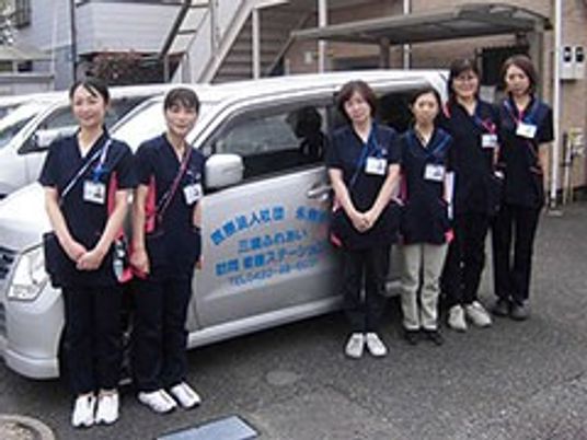 スタッフと送迎車の外観  