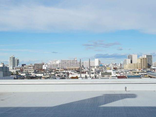 都市の景観と青空 屋上 清々しい青空と都市の眺めが広がる空間で、休息のひと時を。
