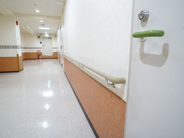 清潔な施設の廊下 手すり 手すりが設置された明るく清潔感のある通路です。安全に配慮したデザインが特徴です。