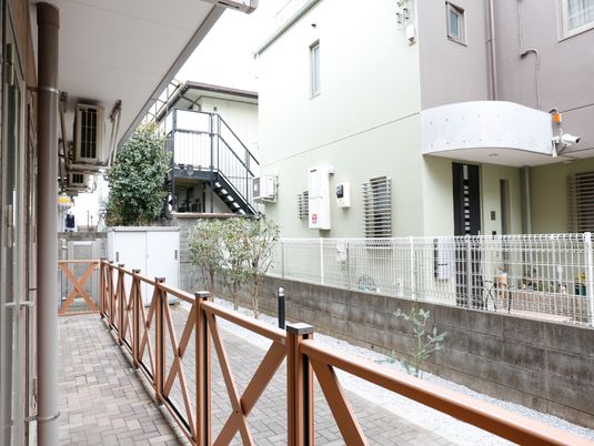 屋外の通路と微笑む人物