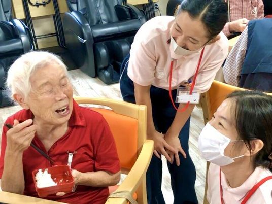 笑顔の老人とスタッフ