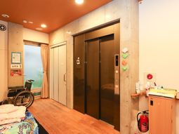 廊下にエレベーターと車椅子