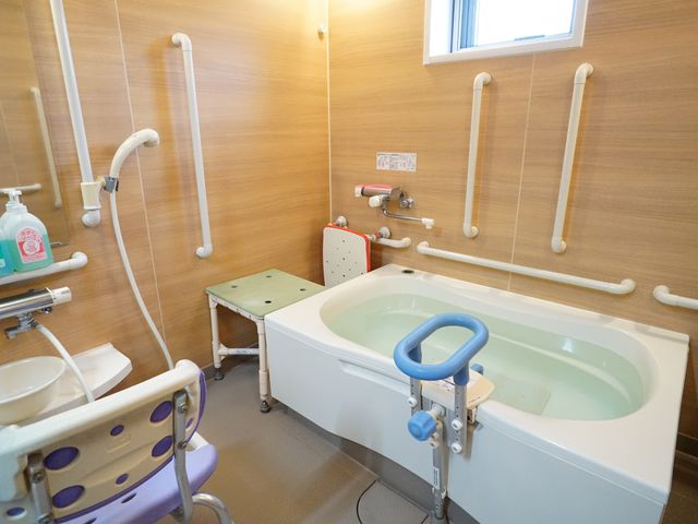バリアフリー浴室設備 浴室 手すりや座席が設置された安全な浴室です。介助が必要な方でも安心してご利用いただける作りになっています。