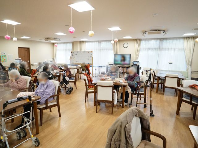 明るい共有リビング 共有スペース 明るく開放的な食堂では、利用者の皆さまがゆったりとした時間を過ごしています。共有スペースでのくつろぎのひとときは、日々の生活の充実につながります。