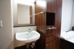 居室内の洗面台とベッド